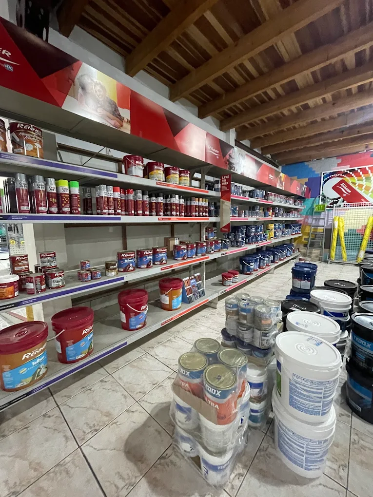 Corredor interno da loja Dallasta com prateleiras completas de tintas e materiais para pintura